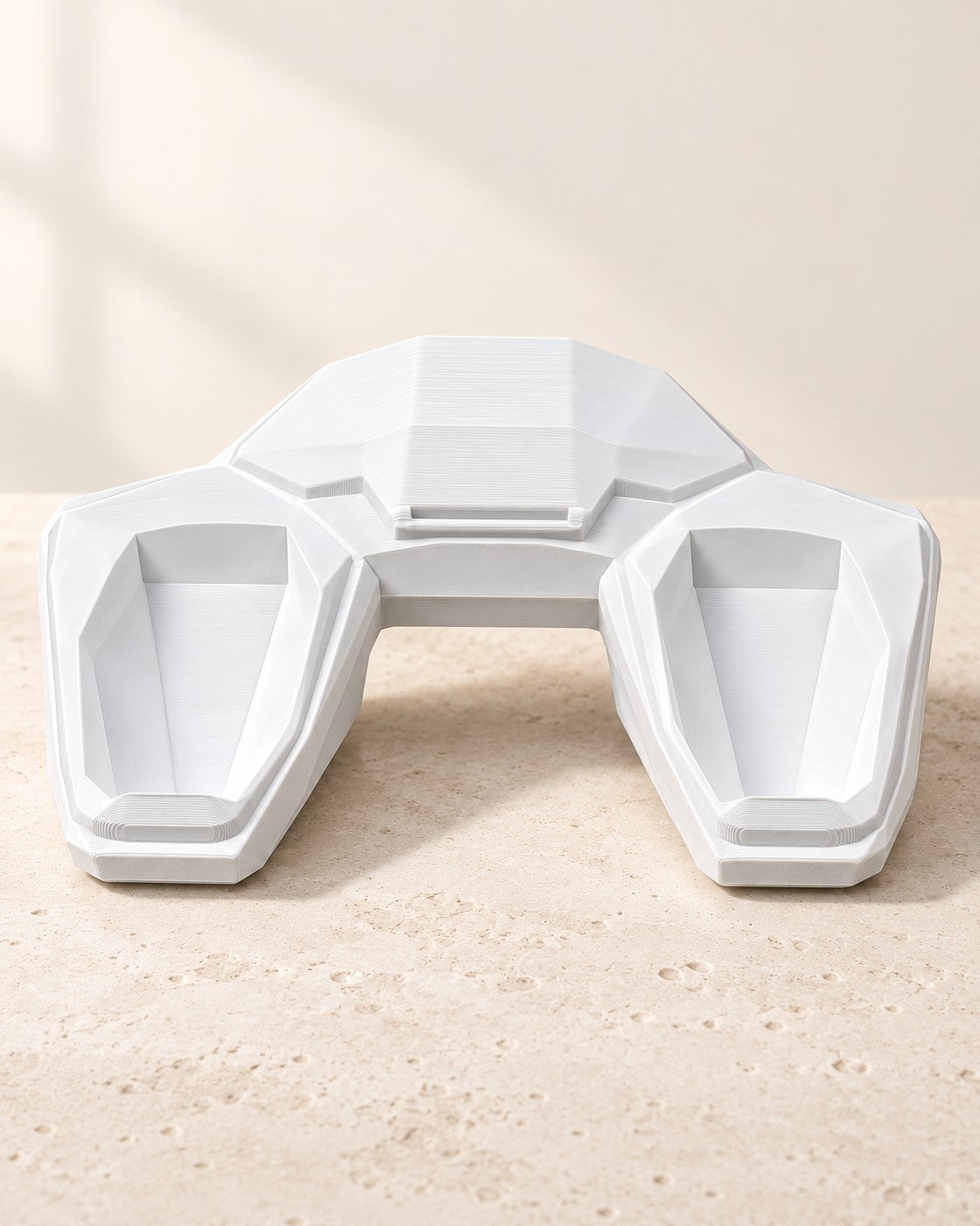 Faceted Controller Stand on a pale limestone plinth, soft studio light