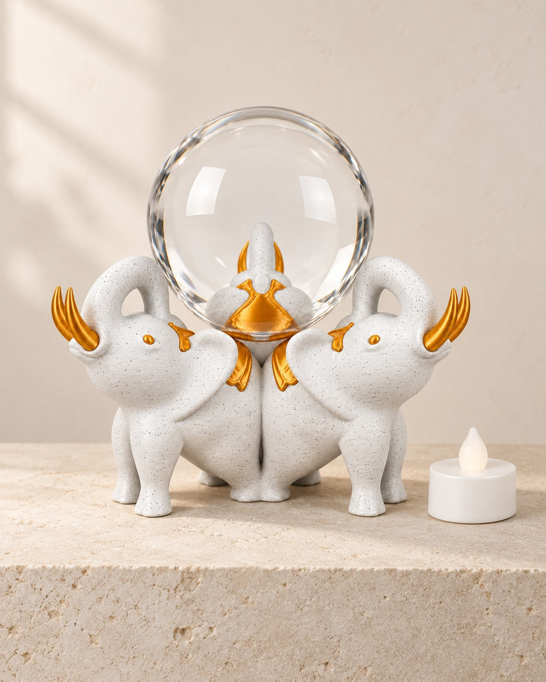 Elephant Trio Crystal Ball Holder on a pale limestone plinth, soft studio light