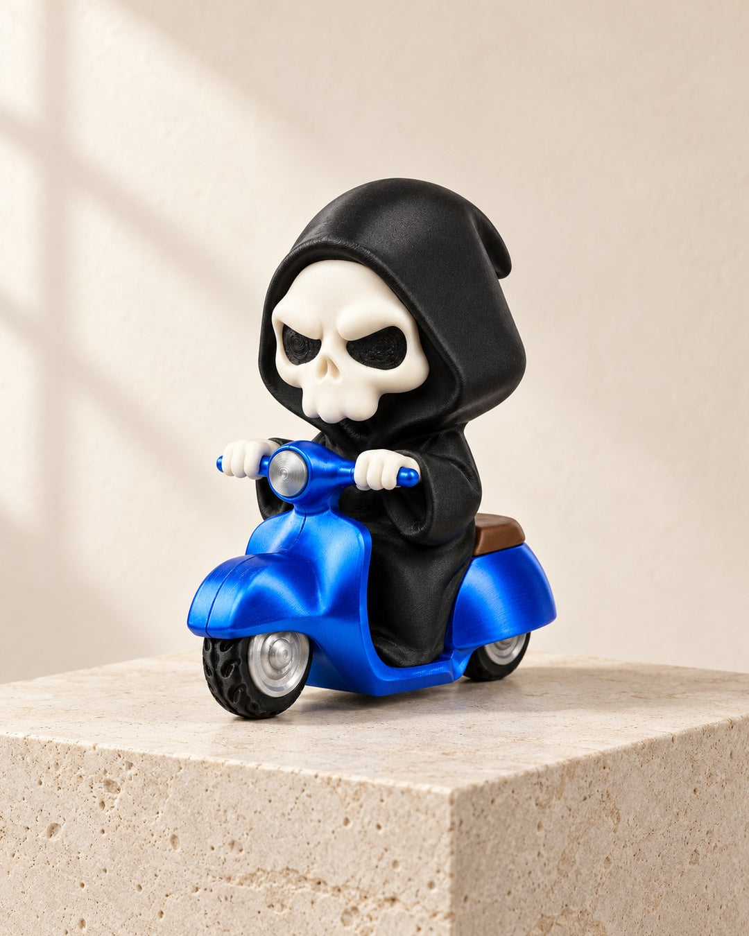 Three-quarter view of a Grim Reaper figurine on a blue scooter with a brown saddle and silver wheel hubs