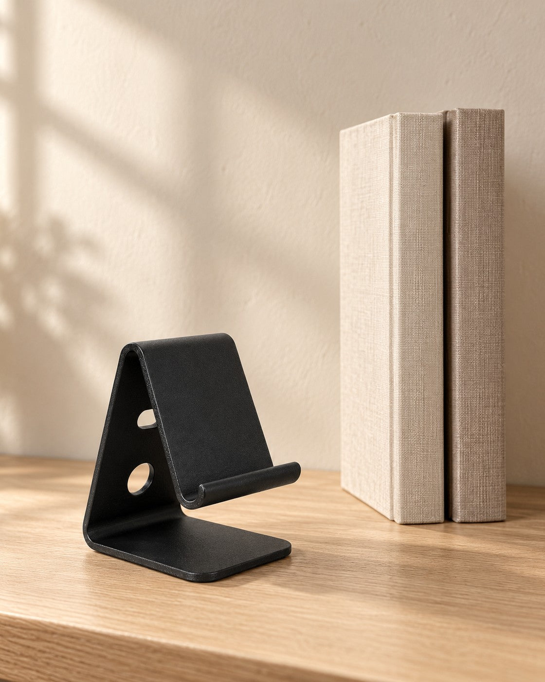 Black Desktop Phone Stand in a calm, softly lit interior, shown at true scale