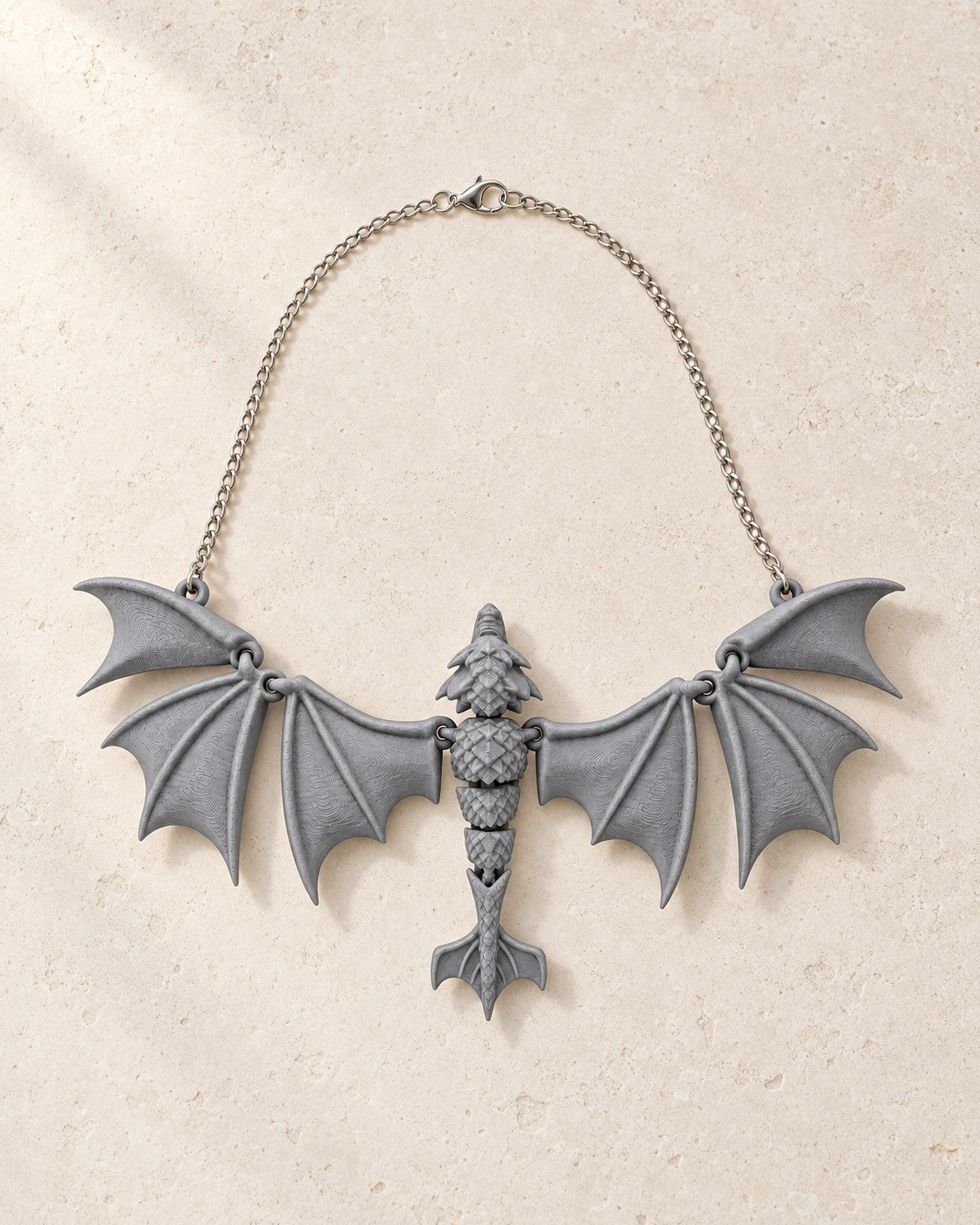Soaring Fang Necklace on a pale limestone plinth, soft studio light
