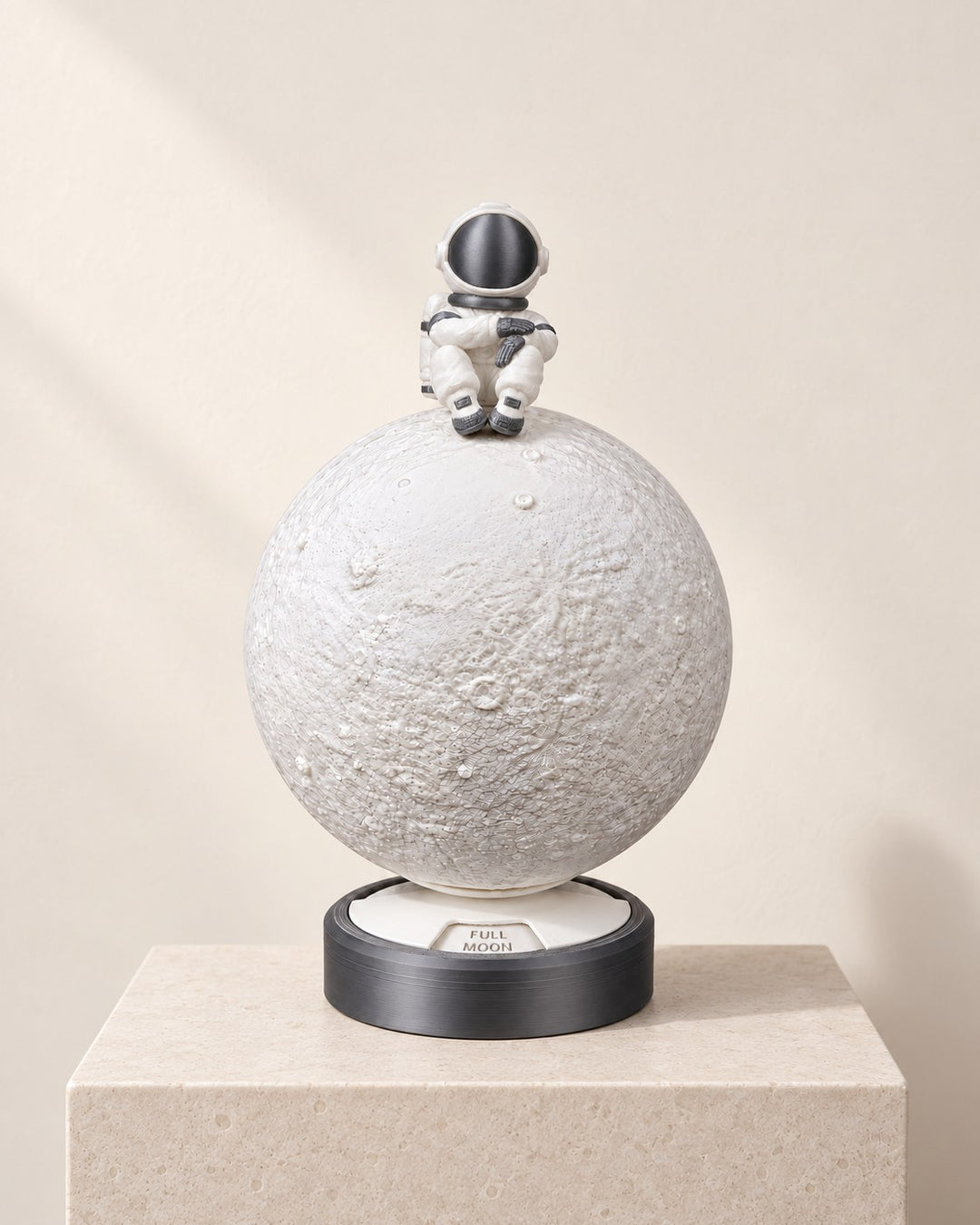 Moon Phase Astronaut Lamp: Crater-textured moon lamp with a seated astronaut and a turning phase base