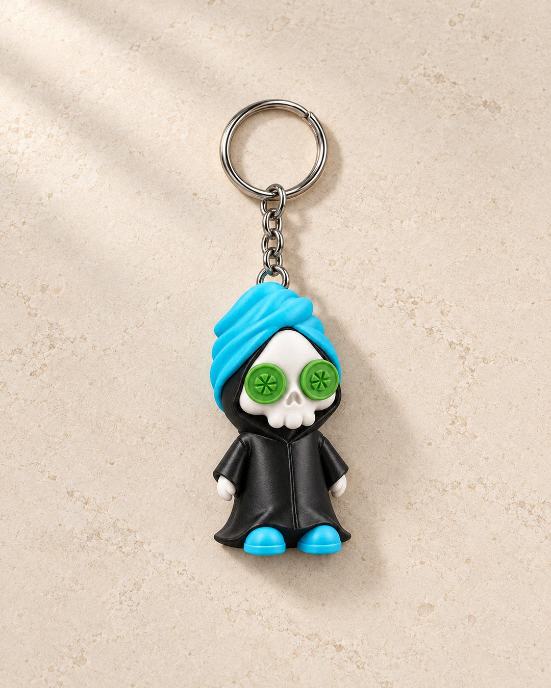 Reap in Peace Keyring: A grim reaper on a spa day, with cucumber eyes, a towel and slippers