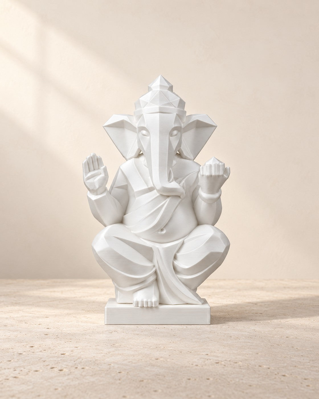 Faceted Ganesha Statue on a pale limestone plinth, soft studio light