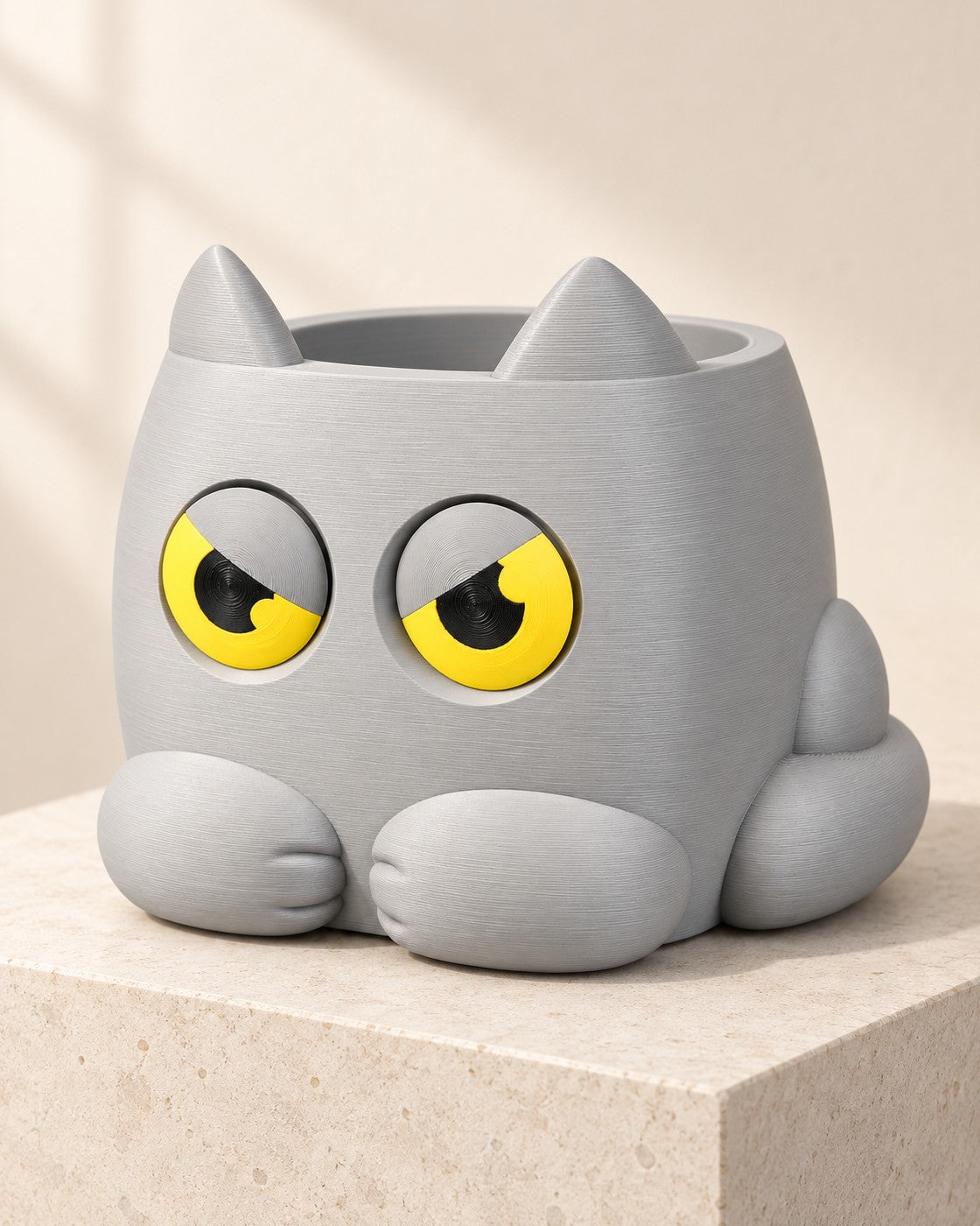 Moody Cat Planter on a pale limestone plinth, soft studio light