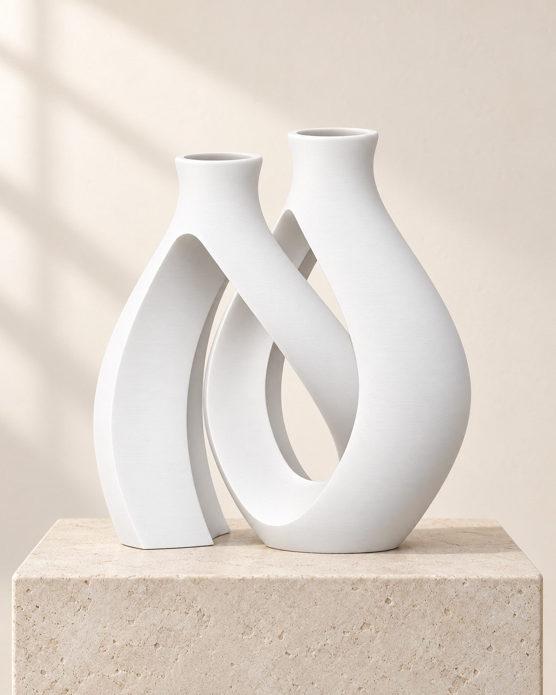 Entwined Vase on a pale limestone plinth, soft studio light
