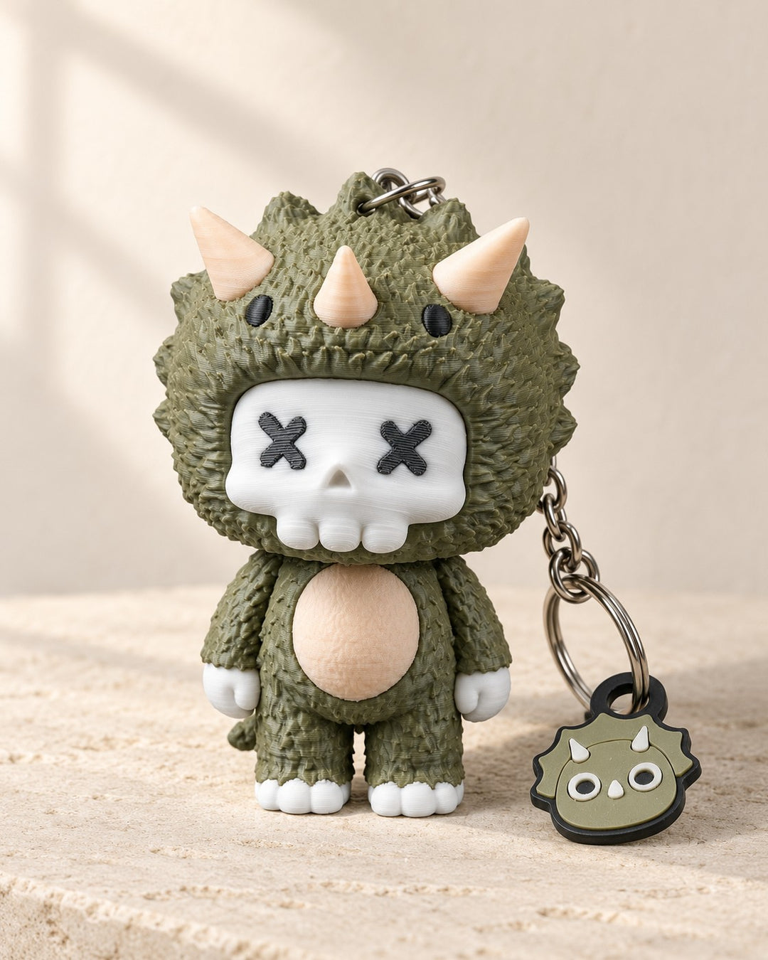 Trixi Skull Keyring: Olive green hooded character charm with a white skull face