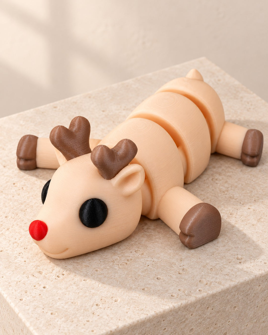 Resting Reindeer Figurine: A cream reindeer flopped flat with a bright red nose