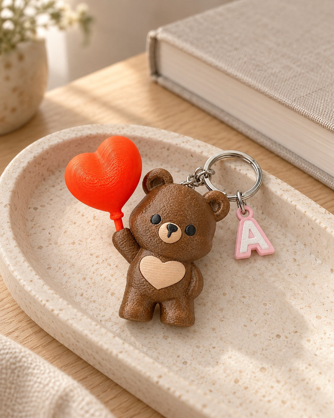 Heart Up Bear Initial Keyring in a calm, softly lit interior, shown at true scale
