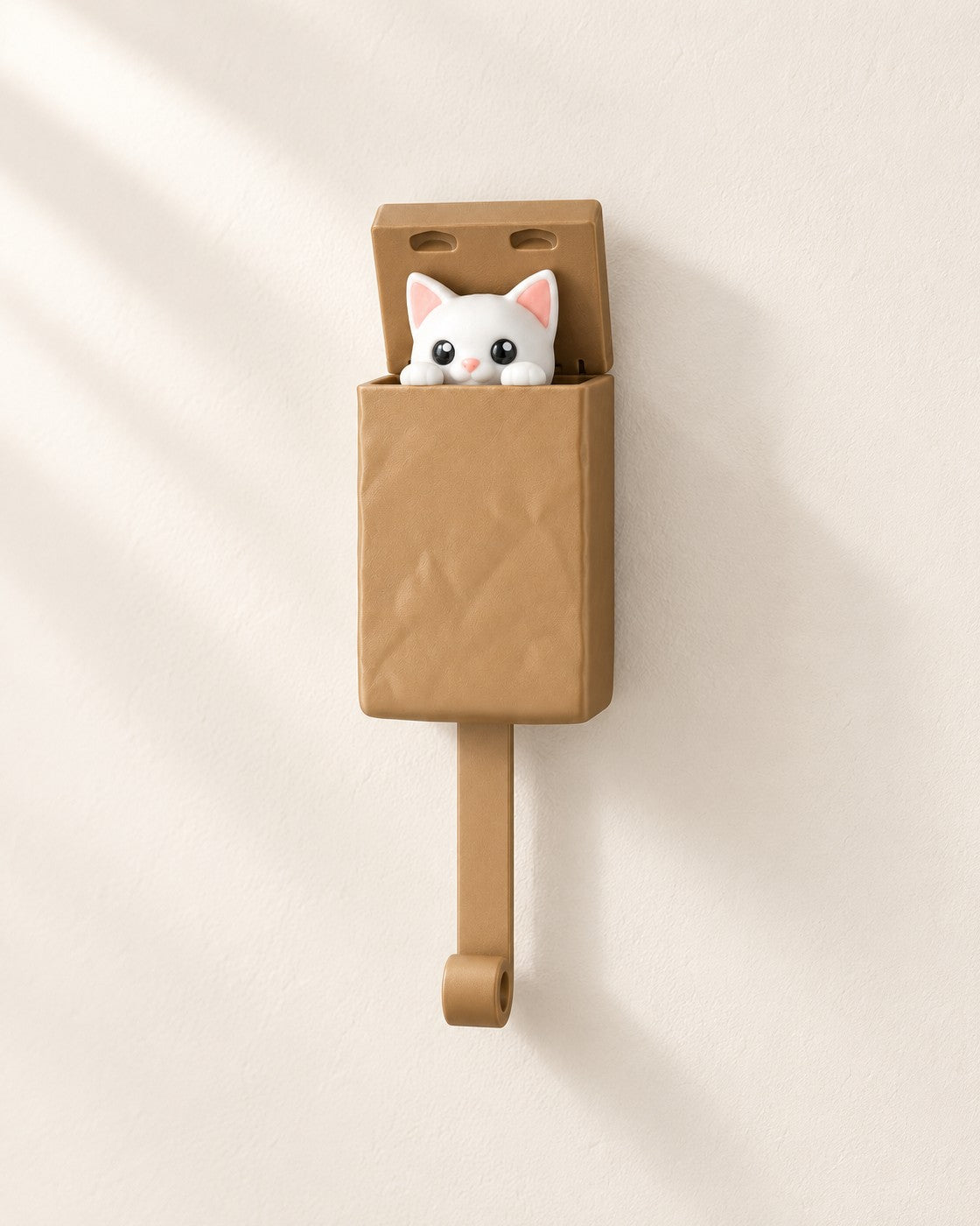 Peeking Cat Key Holder on a pale limestone plinth, soft studio light