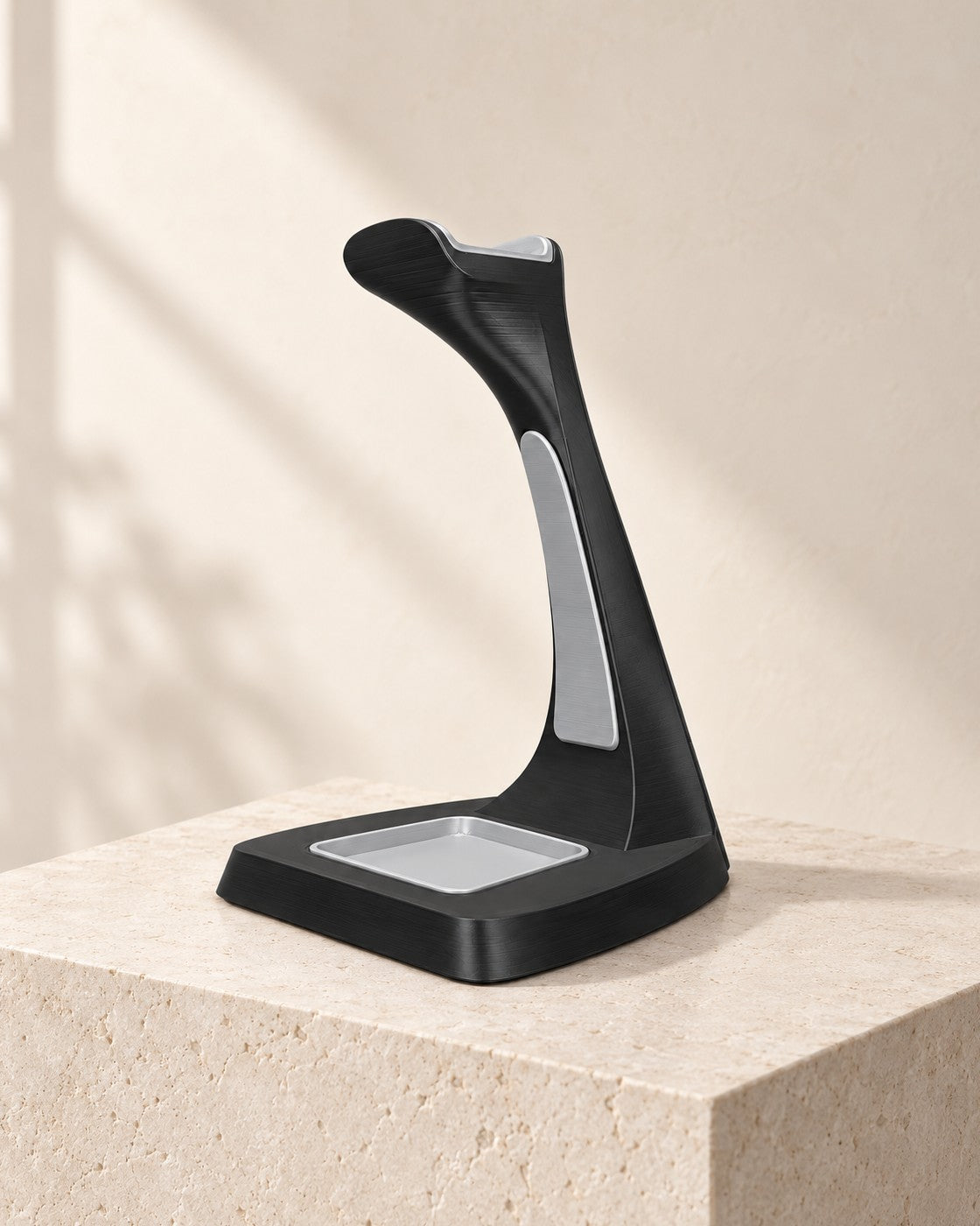 Arch Headphone Stand on a pale limestone plinth, soft studio light