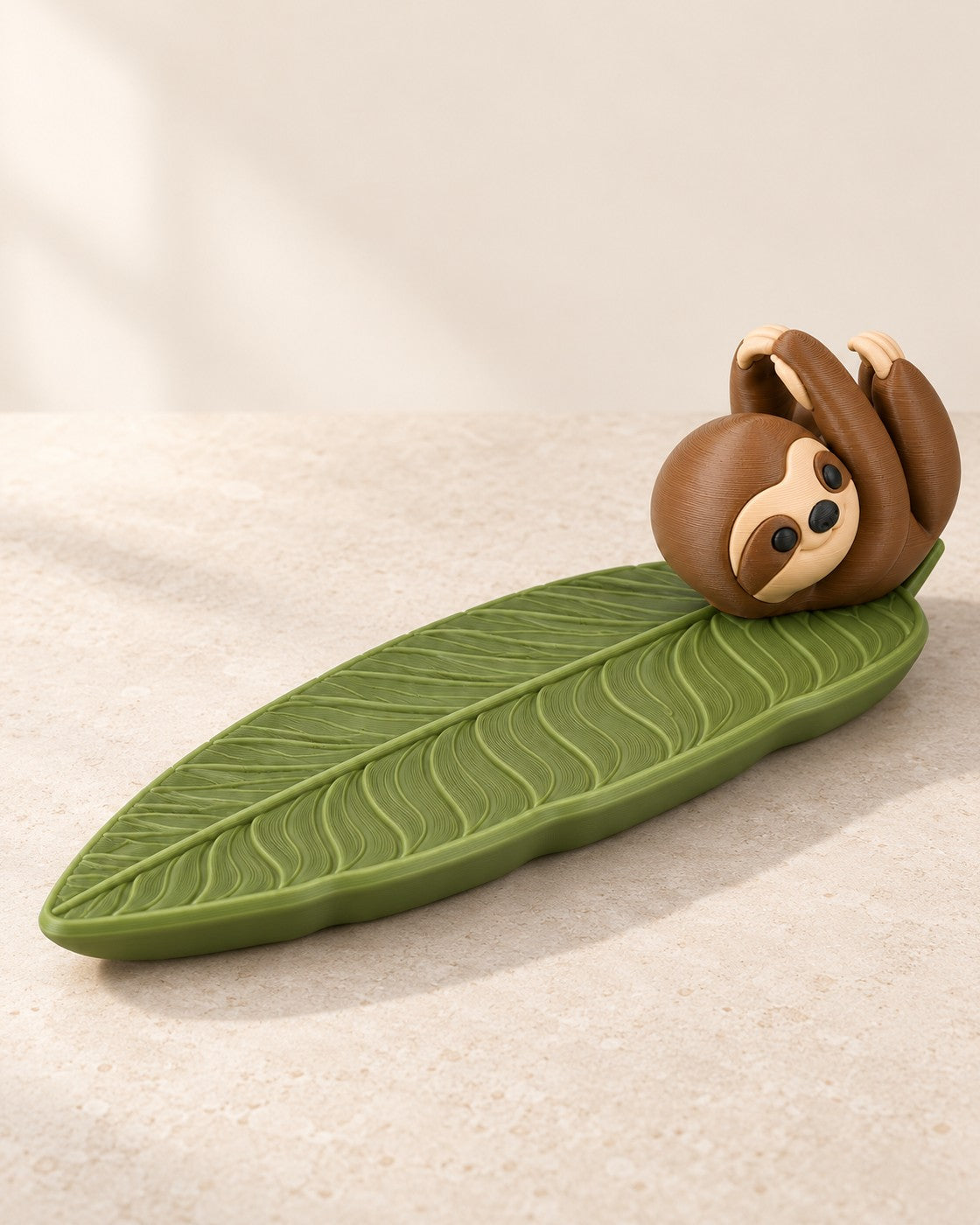 Sloth Incense Holder on a pale limestone plinth, soft studio light