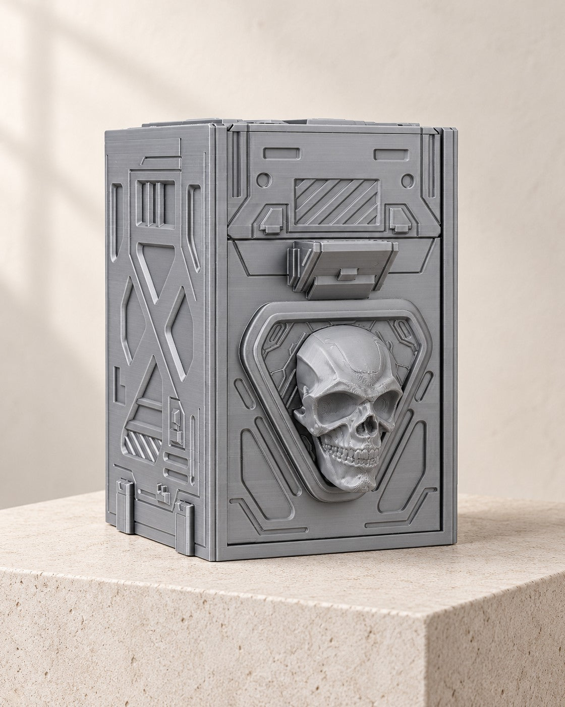 Skull Tilt Deck Box on a pale limestone plinth, soft studio light