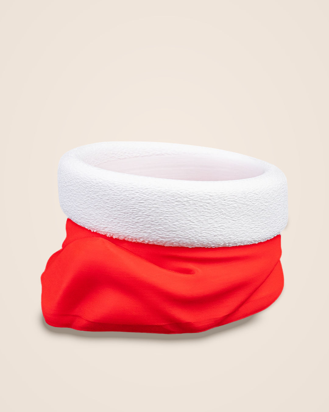 Side view of an empty red and white Santa hat bowl showing the folds of the red body and the white rim on a cream background